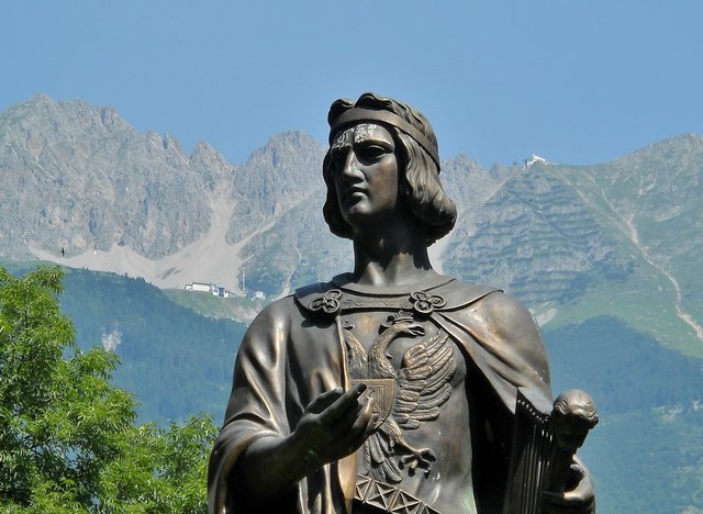 Seine Statue steht im Waltherpark, am linken Innufer in Innsbruck. Hinter ihm die Nordkette mit Seegrube (links) und Hafelekar (rechts).