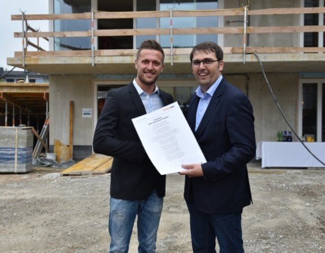 Anton Rieder (r) von der ausführenden Baufirma RIEDERBAU übergibt den Firstspruch an Lukas Steiner (l) von der CGO. | Foto: ofp