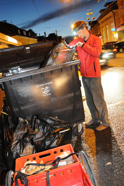 Waste-Diver Lukas Uitz hält Ausschau nach genießbaren Lebensmitteln in der Mülltonne eines Supermarktes.