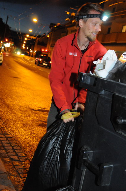 Waste-Diver Lukas Uitz hält Ausschau nach genießbaren Lebensmitteln in der Mülltonne eines Supermarktes.