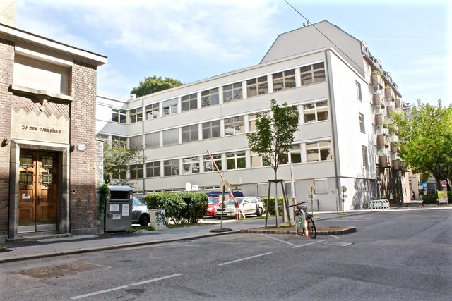 So sieht es derzeit in der Pfeilgasse 42b aus: Direkt vor dem Schuleingang ist ein Parkplatz mit viel Beton und wenig Grün.