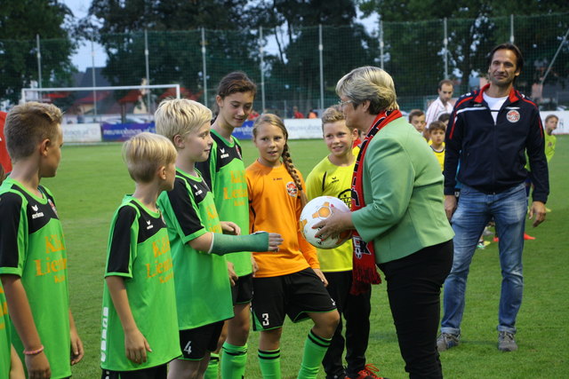 Bgm. Ursula Rauch überreicht den Fußball an den Mannschaftskapitän der U11.