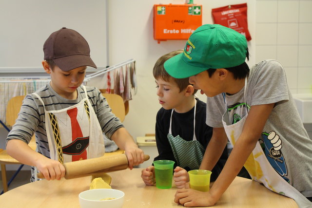 Felix, Peter und Issac rollen den Teig aus