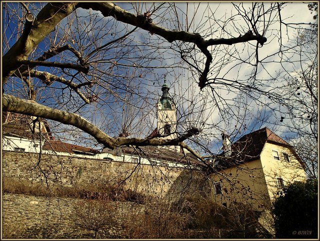 Blick auf die Stadtmauer, im Hintergrund der Westturm der Piaristenkirche.