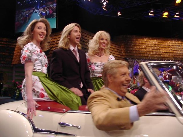 Andi Pirringer singend hoch auf dem weißen Wagen mit Chaffeuer und Stadl-Legende Karl Moik.