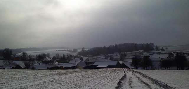 Schnee auf Feld und Dächern, dazu die Wintersunn