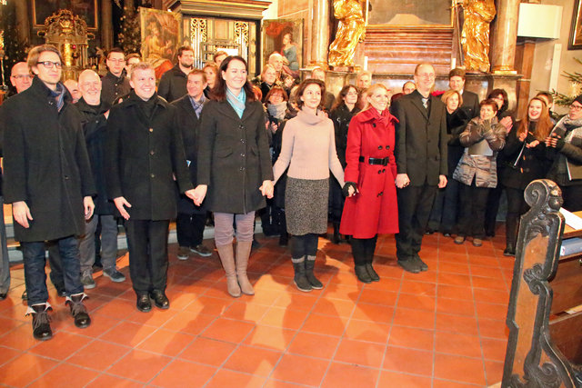 Herbert Handl mit Jelena Widmann, Darina Irmer, Jaroslava Pepper, Markus Sölkner und Florian Widmann (v.r.n.l). Im Hintergrund Mitglieder des Chores und Instrumentalisten.
