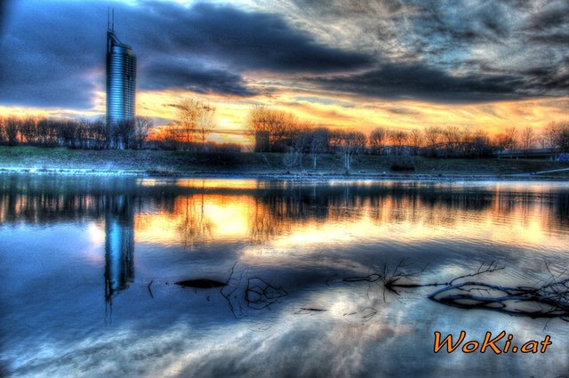 Der Millenium Tower im späten Abendlicht über die Neue Donau hinweg gesehen.