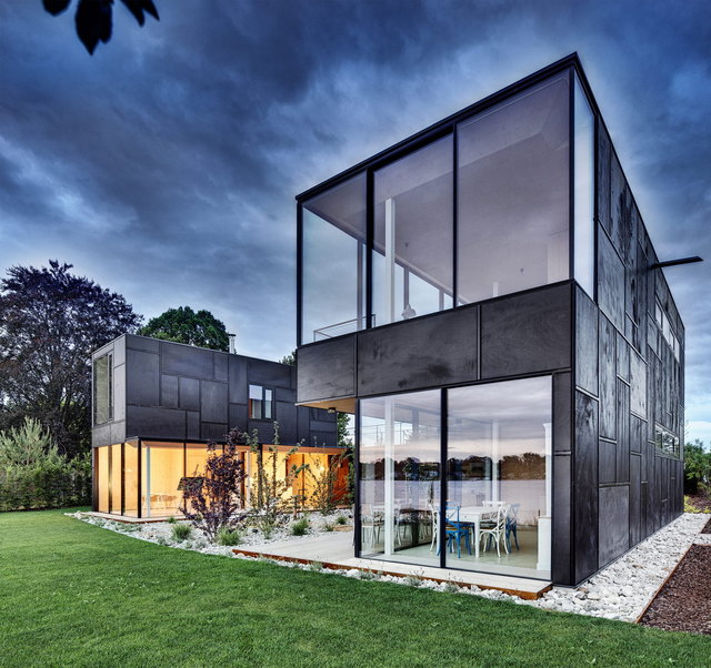 Schwarzes Haus am See: tiefschwarze Fassade trifft transparente Leichtigkeit bei diesem Wochenendhaus, ausgeführt in vorgefertigter Holzriegelbauweise von Holzbau Peter Lottermoser, Pfarrwerfen.
Planung: DI Maximilian Eisenköck, Wien.