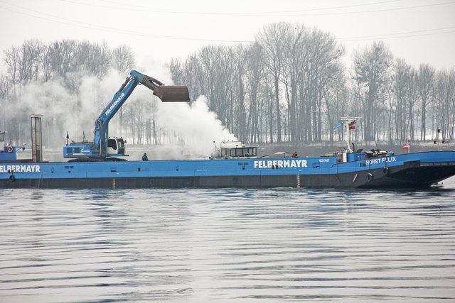 Mit einer Baggerschaufel der Firma Felbermayr wurde das brennende Schiff im Hintergrund übergossen. | Foto: AFK Mauthausen