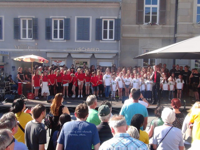 Zum krönenden Abschluss des zweitägigen Festes der Begegnung sang der von Tracy Brighty koordinierte Chor der Chöre mit allen Sängerinnen und Sängern am Rathausvorplatz.