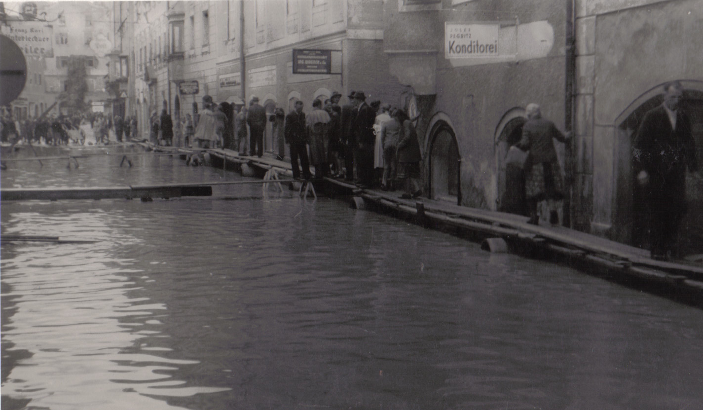 Die Schwazer Innsbrucker Straße war 1948 „Klein-Venedig“. Die Inn-Überschwemmung vom 9. bis 12. August erforderte sogar Stegbau! Im Bild ein Fußgängerstau bei der Konditorei Pegritz.