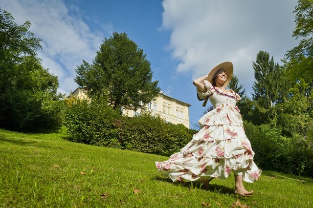 Eine Biedermeierdame genießt den Sommer im satten Grün vor der Villa Wickenburg. | Foto: TVB Region Bad Gleichenberg/Werner Krug