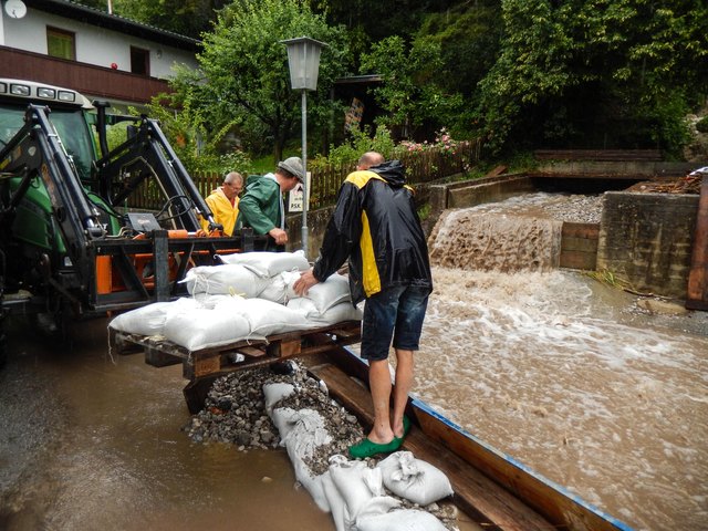Der Möserer Bach in Pettnau bedroht die darunterliegenden Häuser. Die Feuerwehr Pettnau versucht die Wassermassen umzuleiten | Foto: zeitungsfoto.at