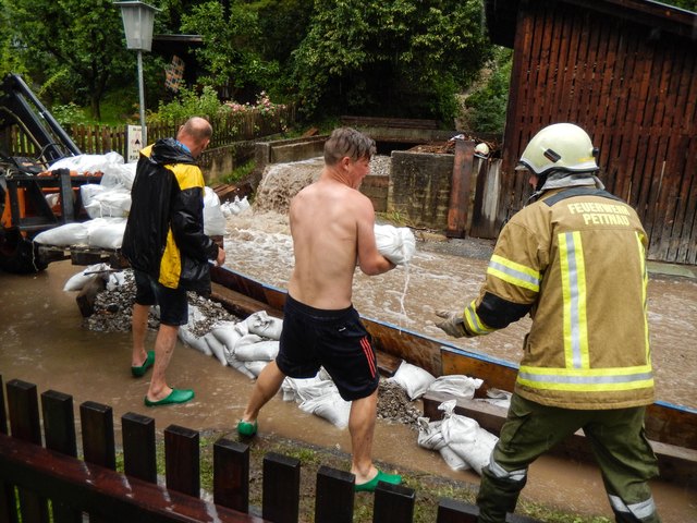 Die Feuerwehr Pettnau versucht die Wassermassen umzuleiten | Foto: zeitungsfoto.at