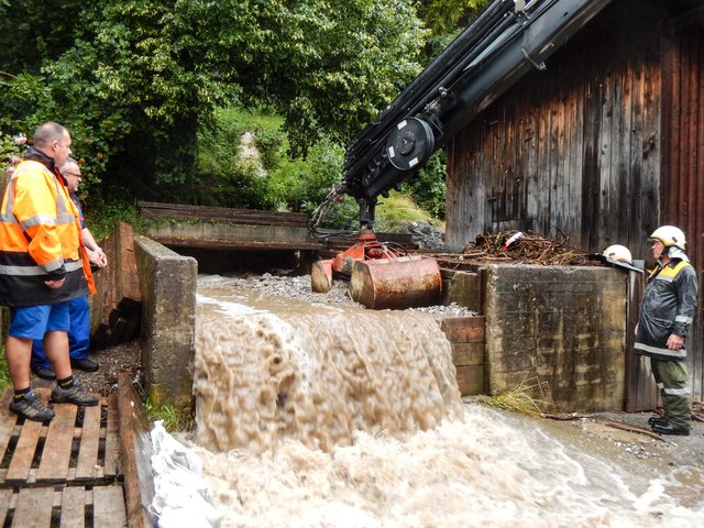 Der Möserer Bach in Pettnau bedroht die darunterliegenden Häuser. Die Feuerwehr Pettnau versucht die Wassermassen umzuleiten. | Foto: zeitungsfoto.at