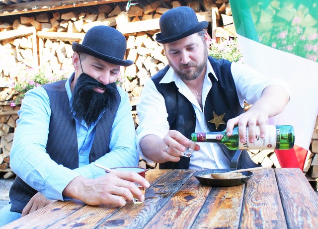 Die Bohnen aus dem Reindl mit Holzlöffel genossen und zum Runterspülen das Feuerwasser;  Peter Linsbichler, Johann Zöhling jun.