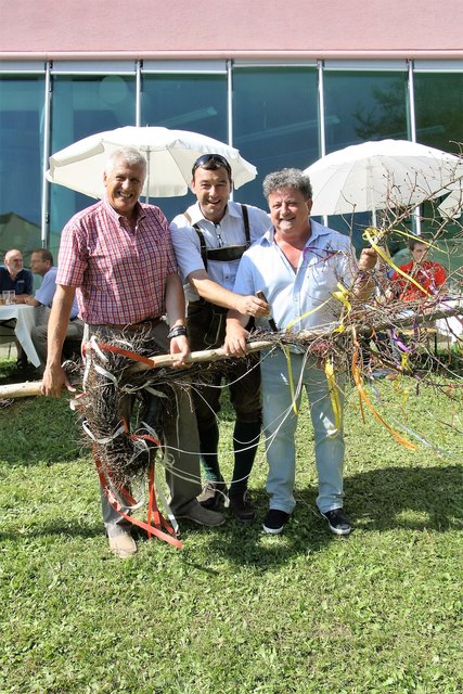 Wolfgang Rappold (Bildmitte) übergibt den ersteigerten Baum an Günther Bauer und Franz Schlögl.