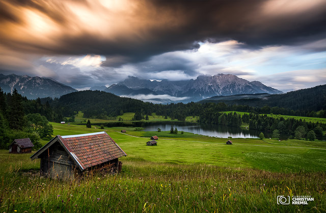 Ich kenne zwar viele Bilder, wollte ihn aber endlich mal selber sehen.
Der Geroldsee, auch Wagenbrüchsee genannt, ist ein Moorsee wenige Kilometer von Garmisch-Partenkirchen entfernt. Von ihm aus hat man einen traumhaften Panoramablick auf das Karwendelgebirge.
Wir kamen am Nachmittag in Gerold an und suchten uns einen Parkplatz. Nach einer kurzen Erkundungsrunde um den See entschieden wir uns für diesen Platz, etwas oberhalb der großen Wiese mit den kleinen Hütten.