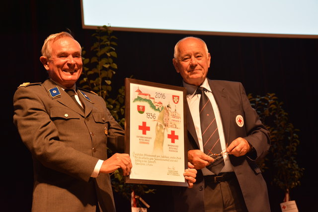 Karl-Heinrich Zeuner (Vorstand BRK Kreisverband RO, re.) überreichte Heinz Scherfler ein besonderes, handgemaltes Bild zum Jubiläum.
