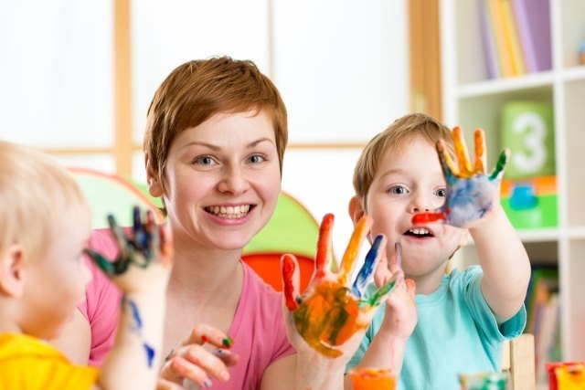 Happy family - mother and sons having fun with paints