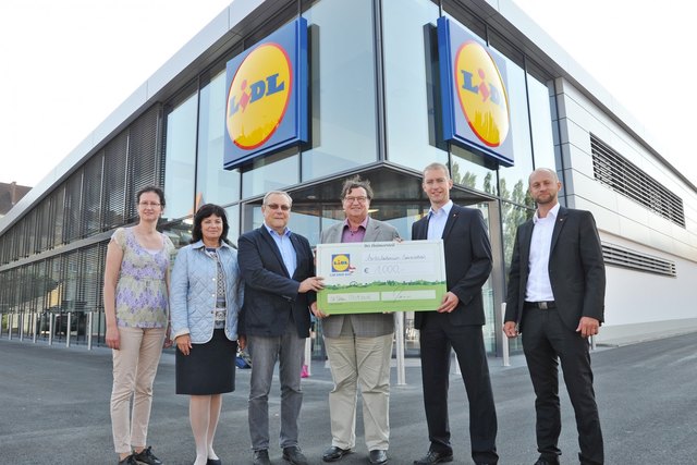 Bei der Eröffnung der neuen Lidl-Filiale engagiert sich Lidl im sozialen Bereich. Das Ambulatorium Sonnenschein kann sich über eine Spende von 1.000 Euro freuen. Mag. Bernadette Schwab von der Wirtschaftsservicestelle ecopoint, Stadträtin Mag. Ingrid Heihs, Ambulatorium Sonnenschein-Direktor Robert Holovsky, Vizebürgermeister Ing. Franz Gunacker, Lidl-Niederlassungsleiter Dipl.-BW (FH) Ronny Bauer und Lidl Immobilienleiter Ing. DI Harald Hargassner mit der Spende vor der neuen Filiale.