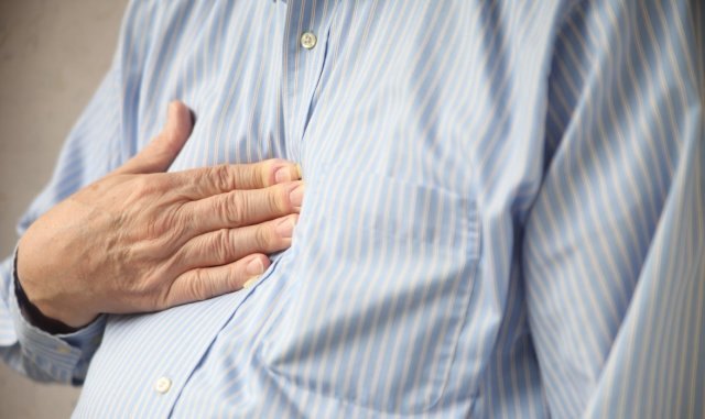 Betroffene einer Angina pectoris spüren einen drückenden Schmerz im Brustbereich.