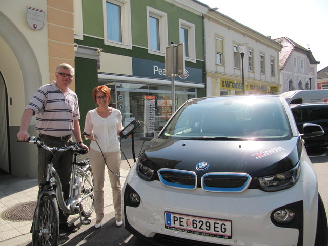Klaus Manner mit einem Leih-E-Bike, wie es der Tourismusverband ab 2017 anbieten wird und Johanna Hiemetsberger mit dem BMW i3 der als „FIBU-mobil“ für das Steuerbüro Dkfm. Martin im Einsatz ist.