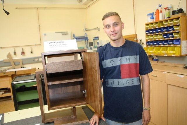 Daniel Knaus mit seinem LAP-Werkstück, einem Wohnzimmer-Barschrank aus Nußholz.
