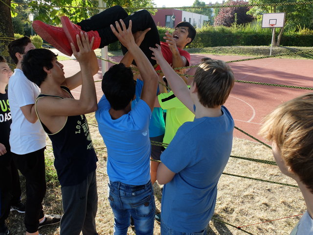 Die Kameraden heben den Schüler sicher durch das "Spinnennetz".