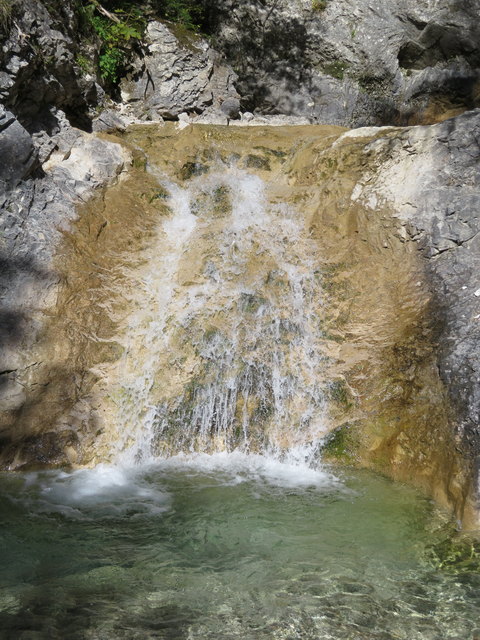 Ein malerischer kleiner Wasserfall an einem der zahlreichen Bäche, die sich von den Berghängen herab ihren Weg Richtung Leutascher Ache suchen