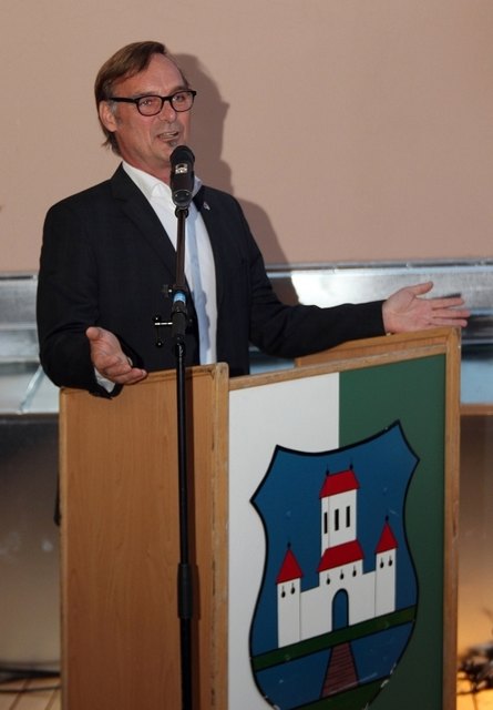 Erwin Eggenreich als letzter Bürgermeister am Rednerpult mit dem alten Stadtwappen