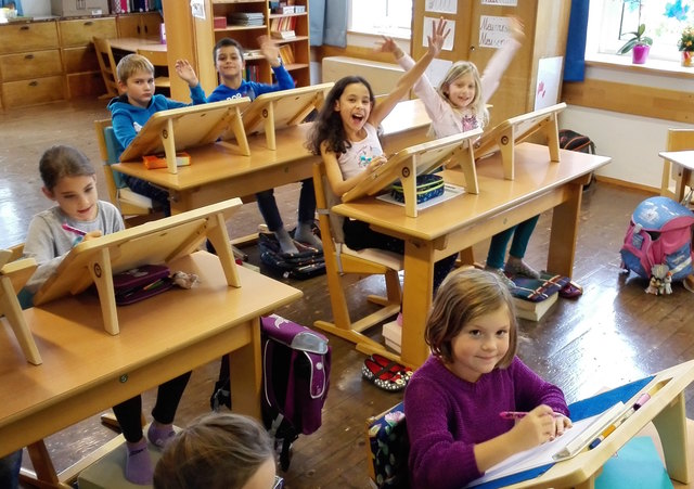 Die Kinder der Volksschule Zipf freuen sich nun über eigene, schräggestelle Tischaufsätze und Rückenpölster.