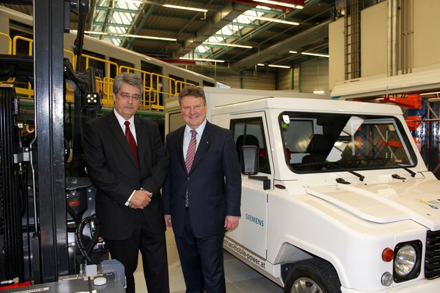 Vostandsvorsitzerder Siemens Ag Österreich Wolfgang Hesoun (li.) mit Wohnbaustadtrat Michaal Ludwig vor dem E-Car für die Werkspostverteilung