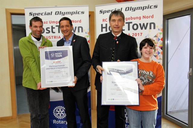 Die Bgm. Harald Mulle/Gratwein-Straßengel und Johann Winkelmaier/Fehring erhalten von Teilnehmern an den Weltwinterspielen Elmar Holzer und Bianca Gruber die Special Olympics-Fahne