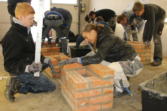 Die Schüler der PTS Münzkirchen mauern in kurzer Zeit geschickt die Ziegel im Bauhof bei Swietelsky auf. | Foto: PTS Münzkirchen