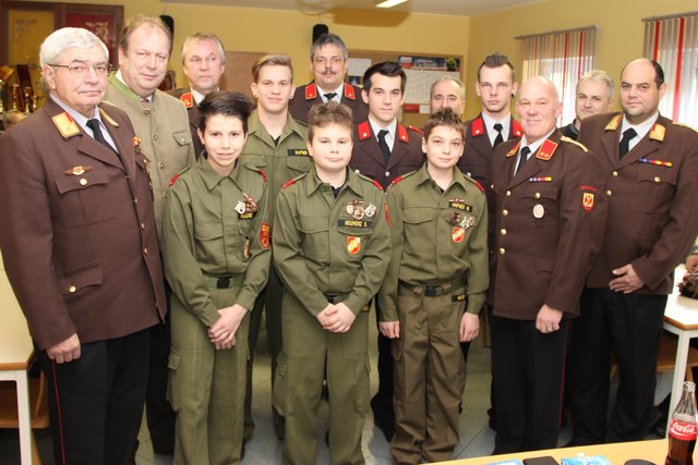 Ehrengäste mit den beförderten Feuerwehrmitgliedern und Jugendfeuerwehrmänner mit ihren errungenen Leistungsabzeichen