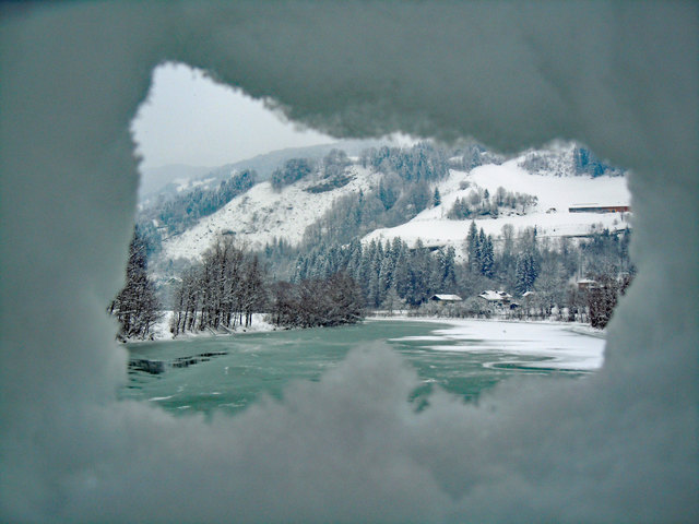 Blick auf die Salzach durch ein Schneeloch.