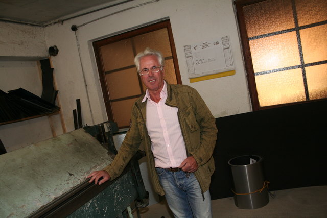 Spengler Reinhold Todt mit der alt­ehr­wür­digen Biegemaschine, die noch immer in der Werkstatt in Grabensee im Einsatz ist.