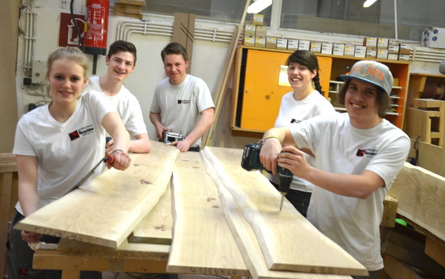 Fünf der aktuell sieben Lehrlinge mit ihrem Werkstoff Holz in der Kienpointner-Werkstätte.