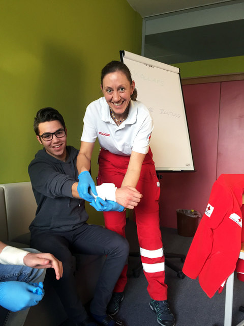 Barbara Graf (Rotes Kreuz Pinzgau) zeigt Fabian Hadjiyski (3AHK) das Anlegen eines Druckverbands.