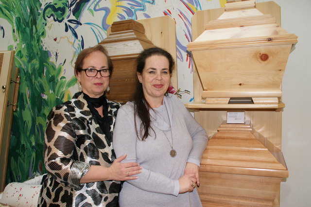 Claudia Jung und ihre Schwester Barbara Perkmann-Jung vor den Sargmodellen aus verschiedenen Holzarten.