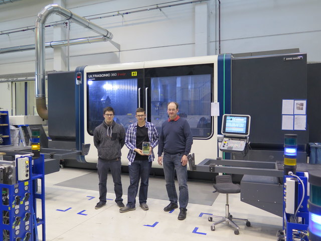Nikolaus Freilinger (v. li.) und Sebastian Krautzer mit Wilfried Maier, Gruppenleiter Industrial Engineering FACC, vor einer Fertigungsanlage, die mit der Black Box in Zukunft überwacht werden soll.