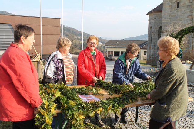 Die Goldhauben-Frauen beim Binden der Kränze für den Brunnen.