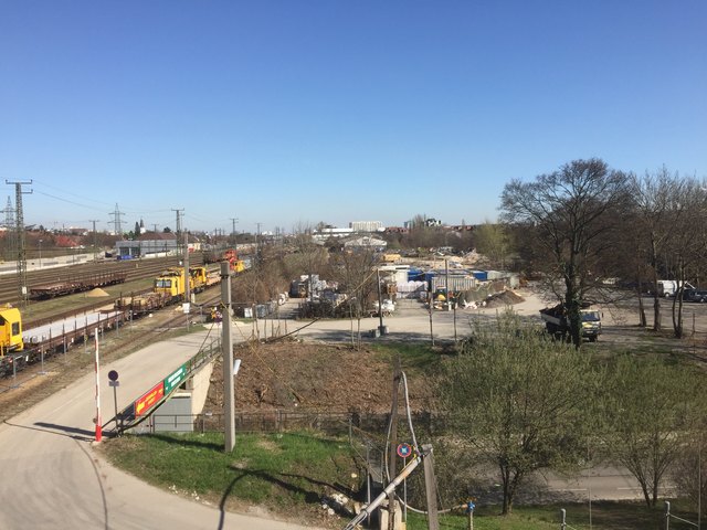 Noch dominieren Baufahrzeuge und Container die Fläche.