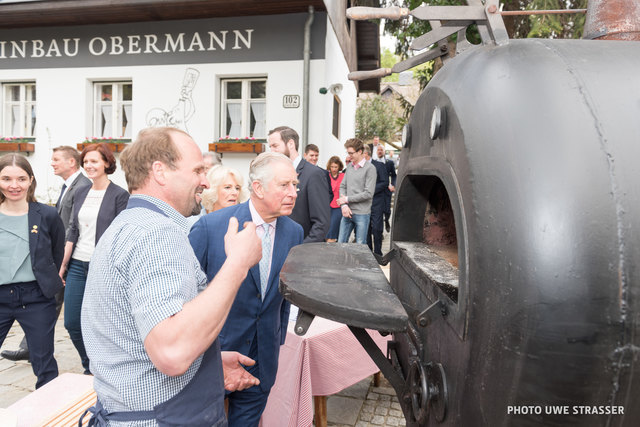 Prinz Charles und seine Frau Camilla lassen sich vom Sarleinsbach Helmut Gragger den Holzofen zeigen und kosten die Käsestangerl, die darin gebacken wurden. | Foto: Uwe Strasser