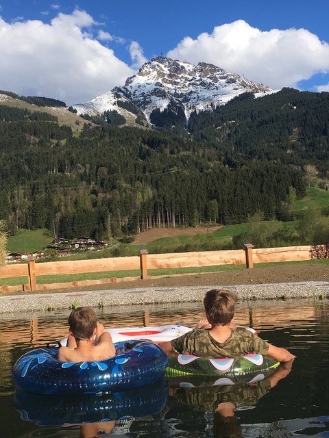 Trotz schneeweißem Kitzbüheler Horn waren Kilian und Julian nicht vom Baden im Teich abzuhalten und genossen die Aussicht