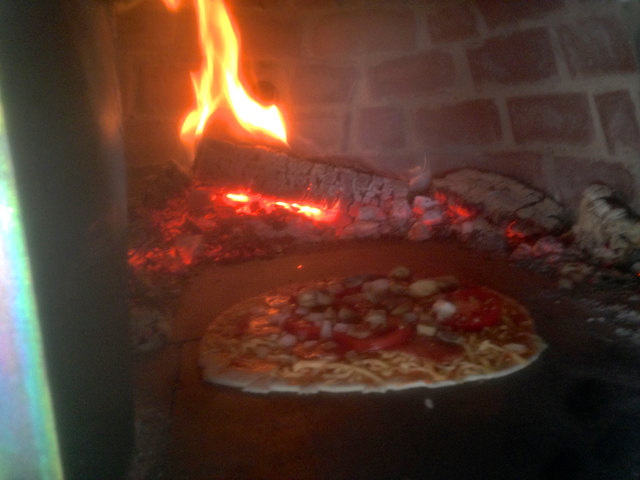 Peischings Bäckermeister Robert Schlief bereitet im Holzherd Schweinsbraten zu. Auch Pizza wird über dem Feuer gemacht.