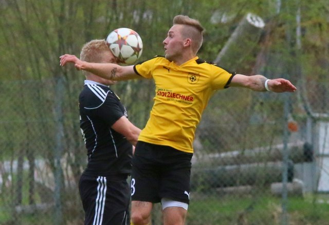 Männer, die Ball und Gegner die Stirn bieten: Michael Schönauer (Walchsee; Schwarze Dress) im Luftkampf gegen Niklas Tengg (SPG St. Ulrich/Hochfilzen)