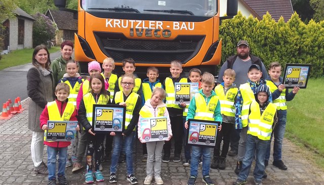 Volksschuldirektorin Tanja Hofer, Klassenlehrerin Karin Baumgartner und Lkw-Lenker Jürgen Reiter mit den Kindern der Volksschule Rattersdorf